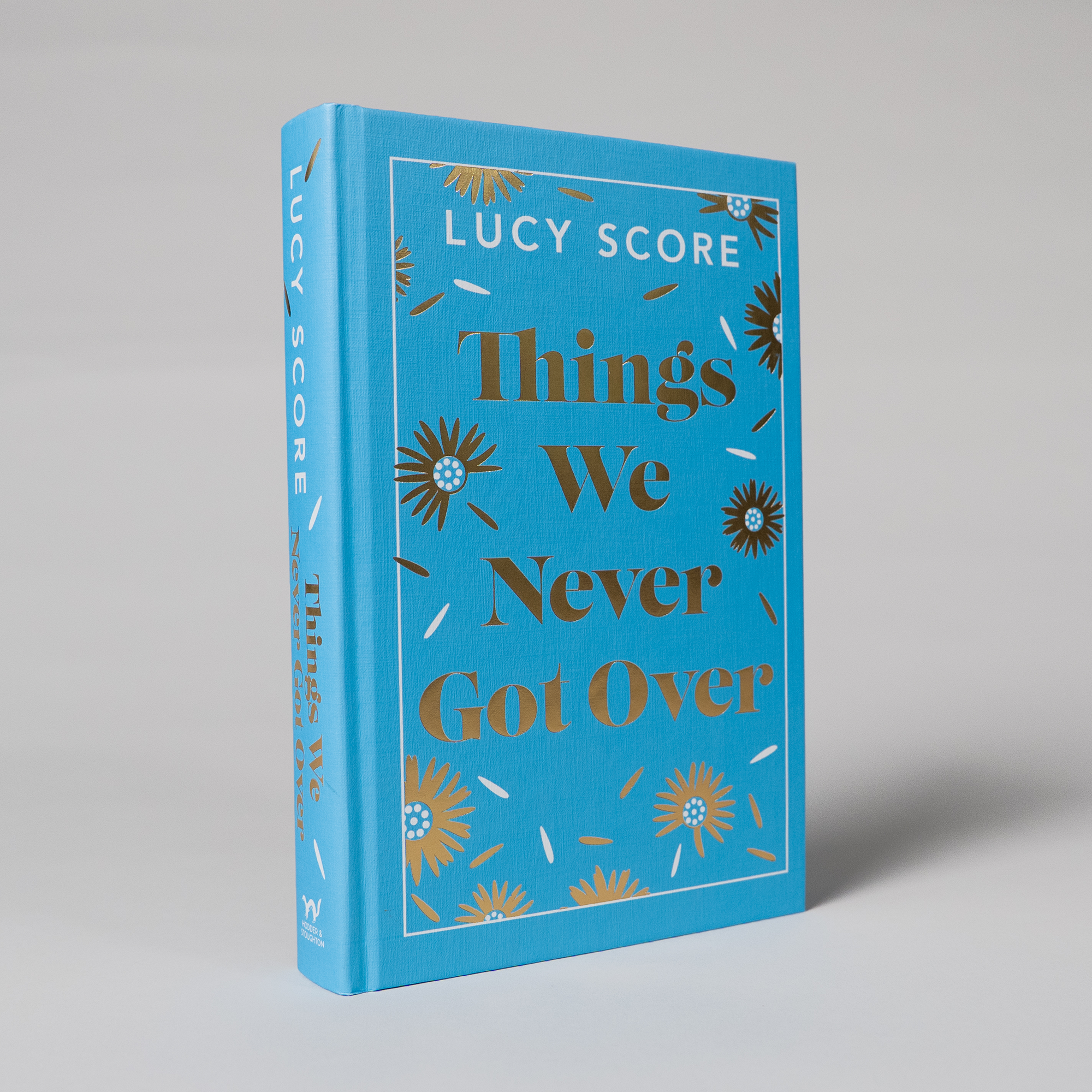 The book is tilted, revealing the spine with gold foil detailing.